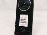 the back of a black cell phone with a barcode on it