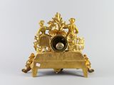 a gold clock that is sitting on a table