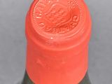 a bottle of wine that has a red cap on it