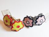 deux boucles d'oreilles posées sur une surface blanche