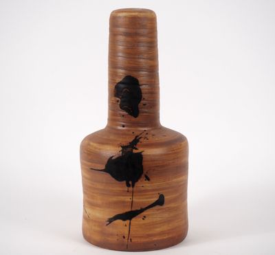 un vase marron orné d'un oiseau noir