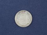 a close up of a silver coin on a blue cloth