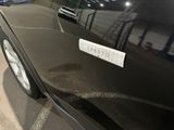 a black car parked in a parking lot with a sticker on the side of it
