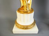 a gold statue of a woman on a marble base