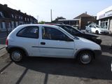 a small white car parked on the side of the road