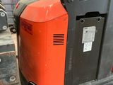 an orange and black forklift sitting on top of a pallet
