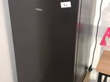 a black refrigerator in the corner of a kitchen