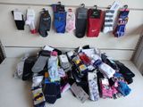 de nombreuses paires de chaussettes accrochées les unes à côté des autres sur le mur