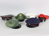 several hats and caps sitting on top of each other on a white surface