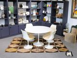 une table et des chaises blanches dans une pièce avec des étagères bleues