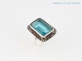 a close up of a ring with a blue stone on it