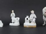 five figurines of people and a dog on a black background
