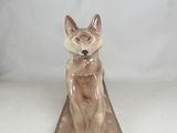 statue of a cat sitting on top of a wooden block