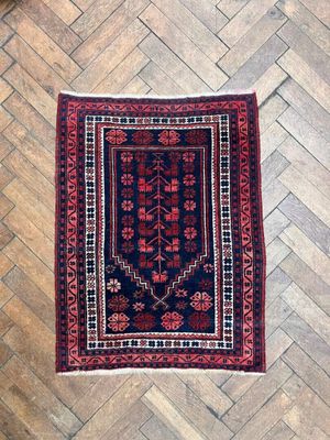 un tapis rouge et bleu posé sur un plancher en bois