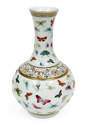 un vase blanc orné de papillons, posé sur une surface blanche