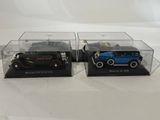 two model cars in a display case on a white surface