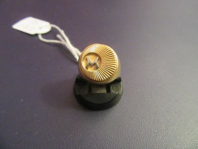 a gold button with a star on it on a black surface