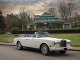 a white rolls royce parked on the side of the road