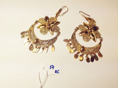 two pairs of gold toned earrings on a white surface
