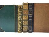trois livres empilés les uns sur les autres sur une surface blanche