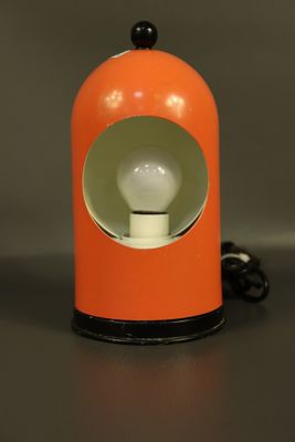 une lampe de table orange surmontée d'une ampoule blanche