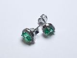 une paire de boucles d'oreilles en cristal vert sur fond blanc