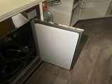 a dishwasher in the middle of a kitchen that is under the counter