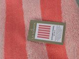 a red and white striped towel with a tag on it