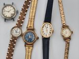 quatre modèles différents de montres-bracelets posés sur un fond blanc