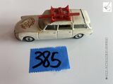 une petite voiture miniature avec un nœud rouge sur le toit