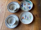 four plates and cups sitting on a wooden table