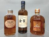 trois bouteilles d'alcool posées les unes à côté des autres sur une table