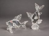 pair of silver fish figurines with red and white accents