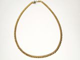 a gold rope necklace with a diamond on a white background