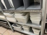 many bins and containers on the shelves in the kitchen