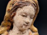 an old statue of a woman with a flower in her hand