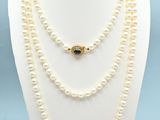 a close up of a necklace with pearls on a mannequin