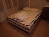 a bed with a white sheet on top of it in a room