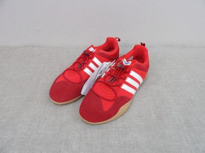 baskets Adidas rouges avec des bandes blanches sur les semelles