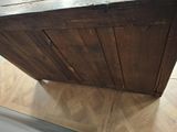 a wooden table with a metal top on a wooden floor