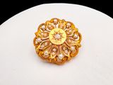 an image of a gold brooch with pearls on top of a white plate