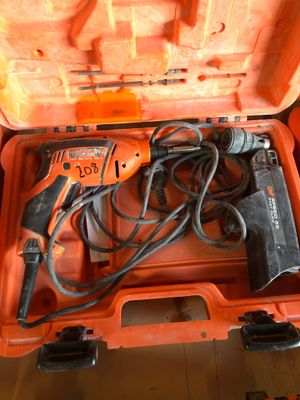une boîte à outils orange contenant une perceuse filaire et d'autres outils