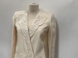beige jacket on a mannequin stand against a white backdrop