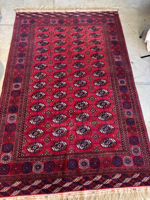 un tapis rouge posé sur le sol, avec une chaise à l'arrière-plan