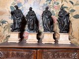 trois statues posées sur un meuble en bois dans une pièce