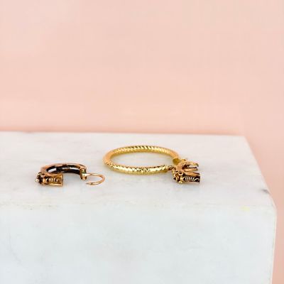 a pair of gold hoop earrings on a marble block