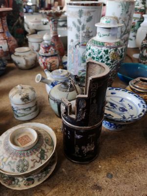 de nombreux vases et assiettes sur la table dans cette pièce