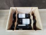 trois bouteilles de vin dans un coffret en bois sur une table