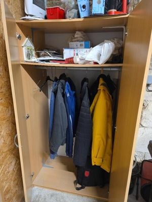 une armoire en bois sur laquelle sont posés des vêtements et d'autres objets
