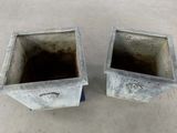 two cement planters sitting on a cement floor